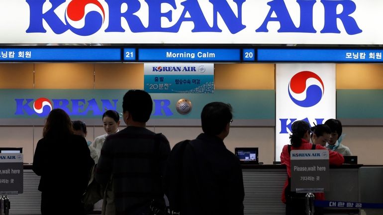 Passengers approach a Korean Air counter at Gimpo airport in...