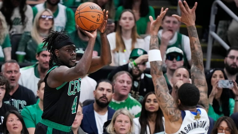 Boston Celtics guard Jrue Holiday takes a shot over Dallas...
