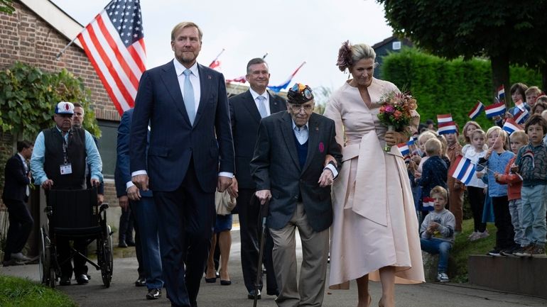 World War II veteran Kenneth Thayer is escorted by Dutch...