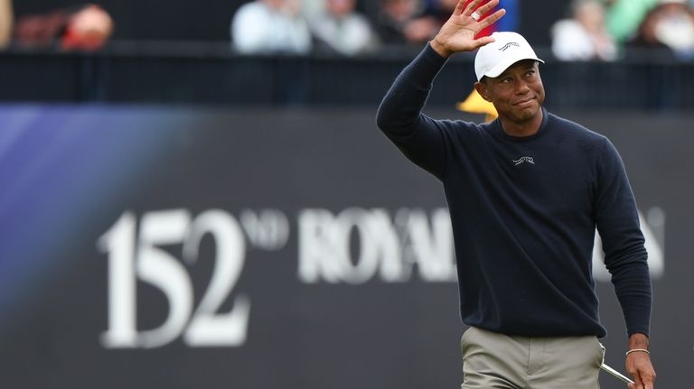 Tiger Woods of the United States waves as he walks...