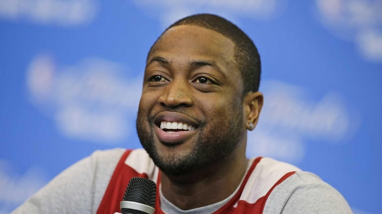 Miami Heat guard Dwyane Wade smiles as he is asked...