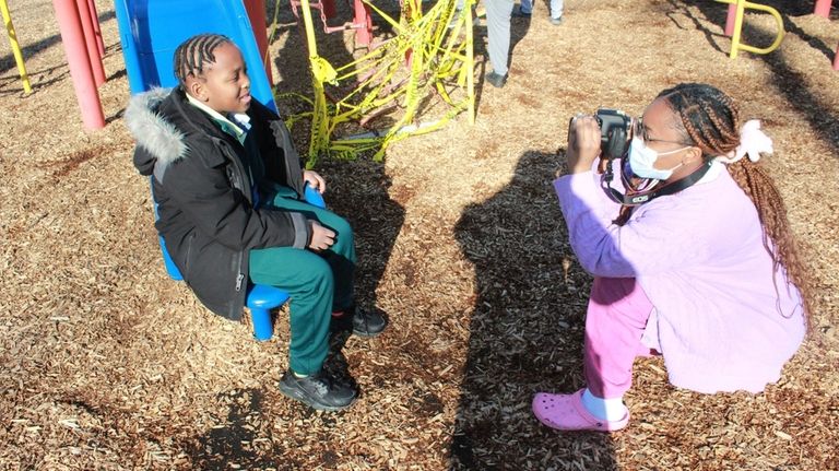 High school student Jamila Bennett takes a photo of Makhi Rhino...