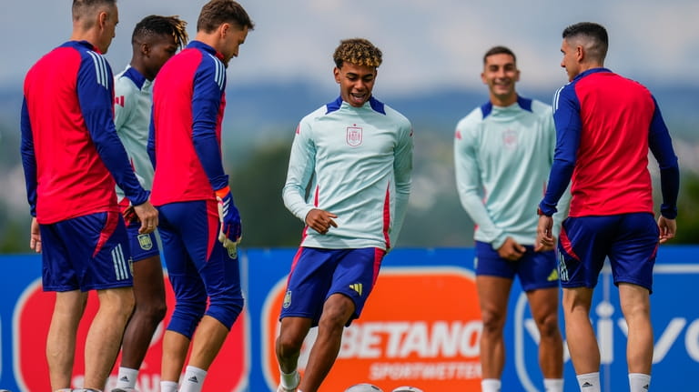 Spain's Lamine Yamal, center, takes part in a training session...