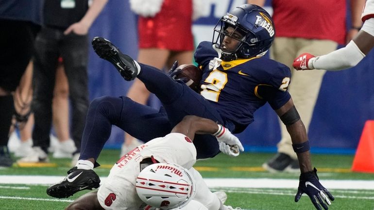 Toledo receiver Junior Vandeross III flips over Miami (Ohio) defensive...