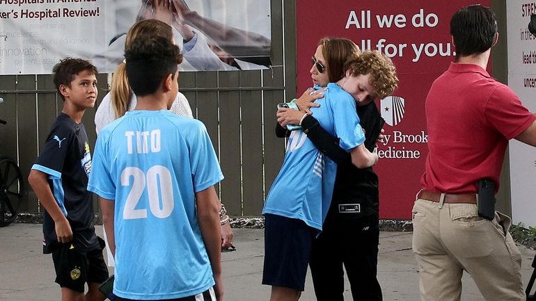 Claudia Stinson, the mother of Anthony Stinson, embraces one her...