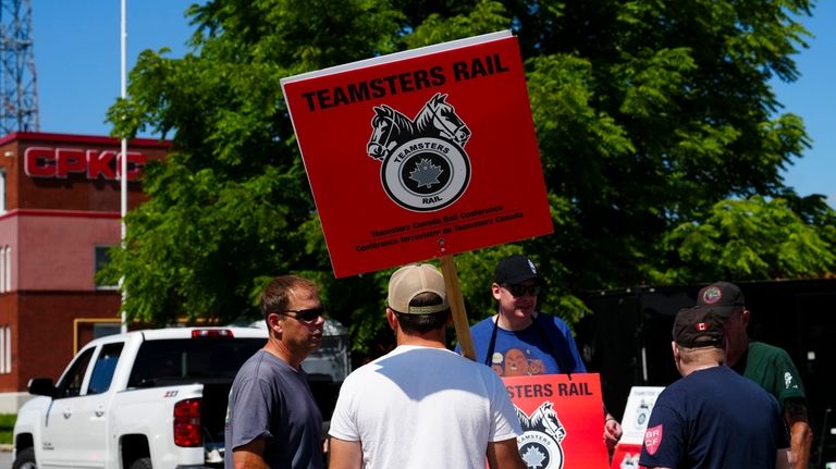 Picketer carry Teamsters Rail placards at a Canadian Pacific Kansas...