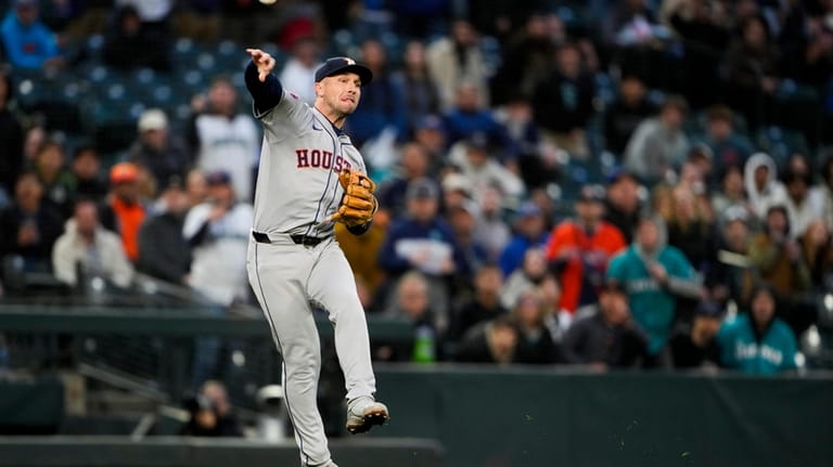 Houston Astros third baseman Alex Bregman makes a throwing error...