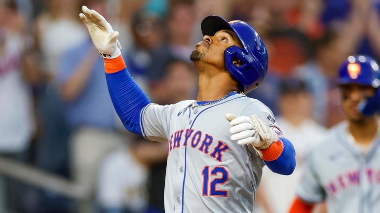 The Mets' Francisco Lindor celebrates at home plate after hitting...