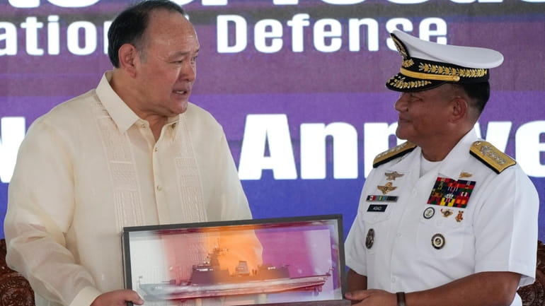 Philippine Defense Secretary Gilberto Teodoro, left, receives a memento from...