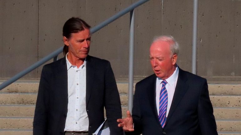 Montauk fisherman Christopher Winkler, left, confers with lawyer Peter Smith of...