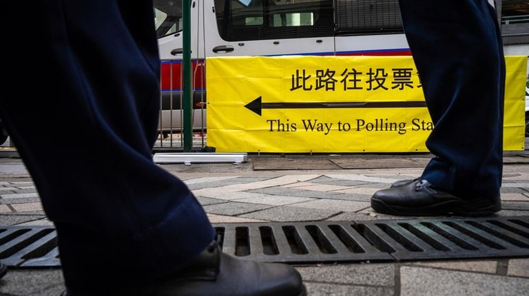 Police officers patrol outside a polling station during the District...