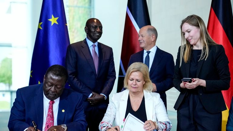 German Interior Minister Nancy Faeser, down right, signs a migration...