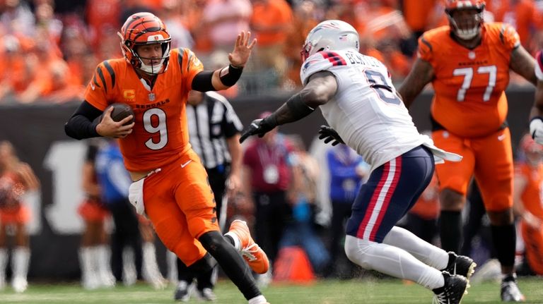 Cincinnati Bengals quarterback Joe Burrow (9) runs from New England...