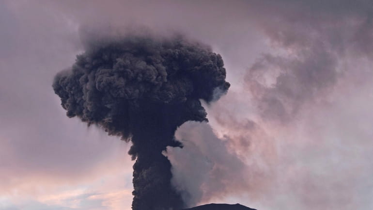 Mount Marapi spews volcanic material from its crater during an...