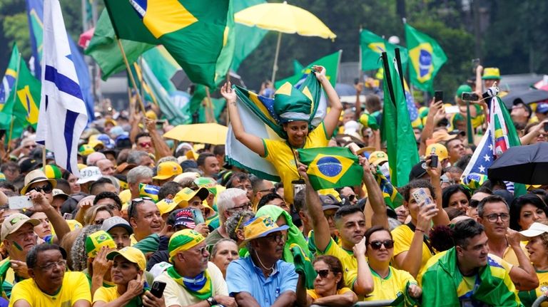 Followers of former Brazilian President Jair Bolsonaro rally to express...