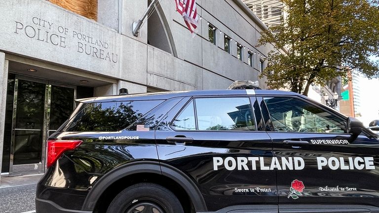 A police vehicle is parked outside police headquarters in Portland,...