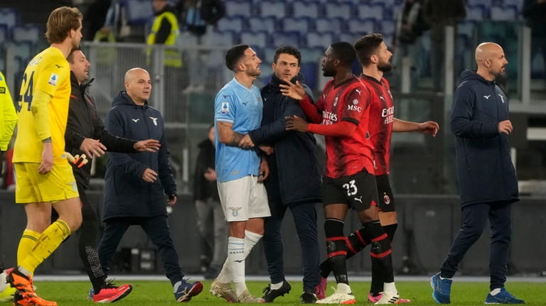 Lazio's Danilo Cataldi, left, argues to Milan players after the...
