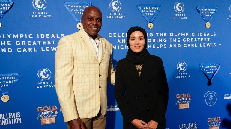 Former Olympian Carl Lewis, left, and representer of the IOC's...