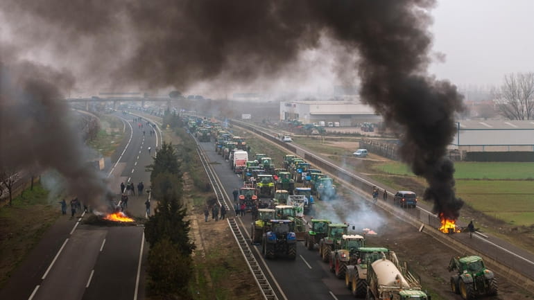 Farmers make barricades after blocking a highway during a protest...