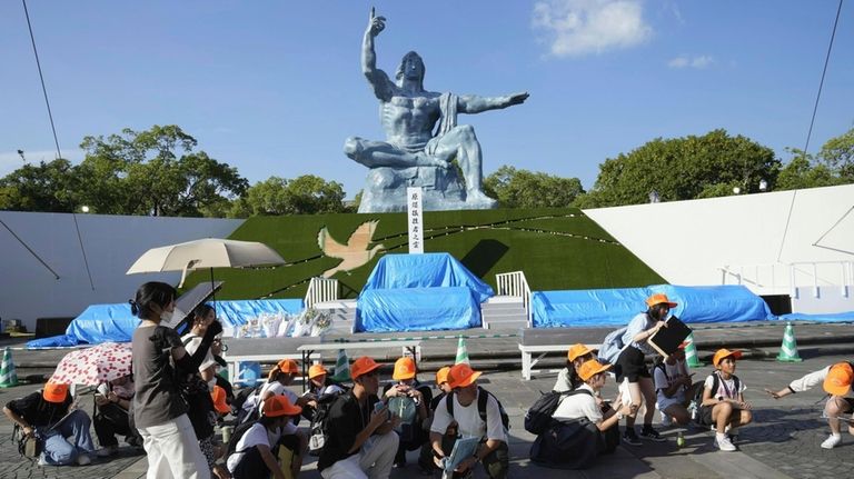 Visitors to the Peace Park crouch as an earthquake alert...