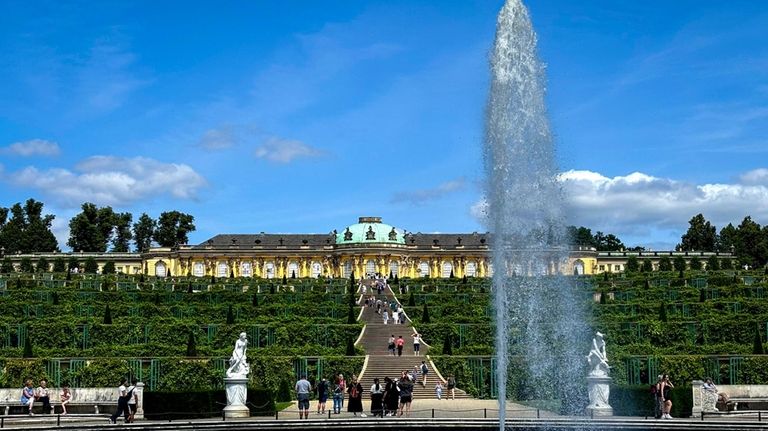 A fountain sprays water at the bottom of the Sanssouci...