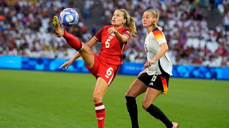 Canada's Cloe Lacasse fights for the ball with Germany's Janina...