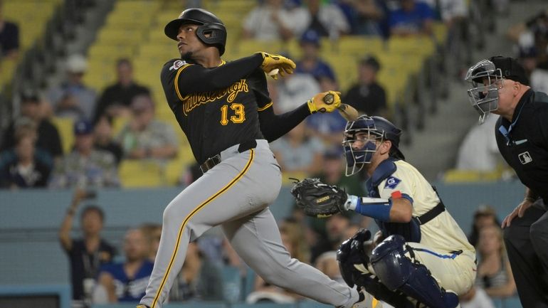 Pittsburgh Pirates' Ke'Bryan Hayes (13) hits a solo home run...