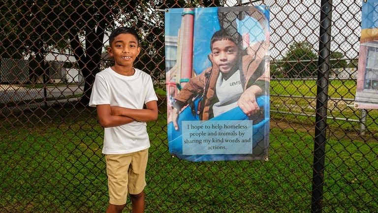 Ethan Boodram, 8, stands next to the portrait of himself,...