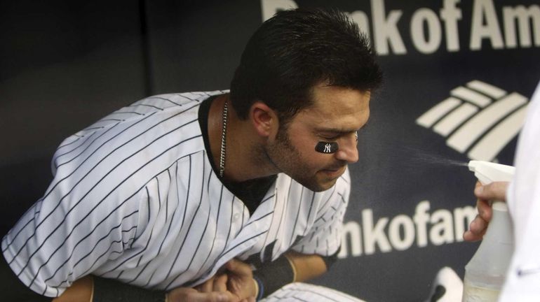 New York Yankees' Nick Swisher is cooled down with a...