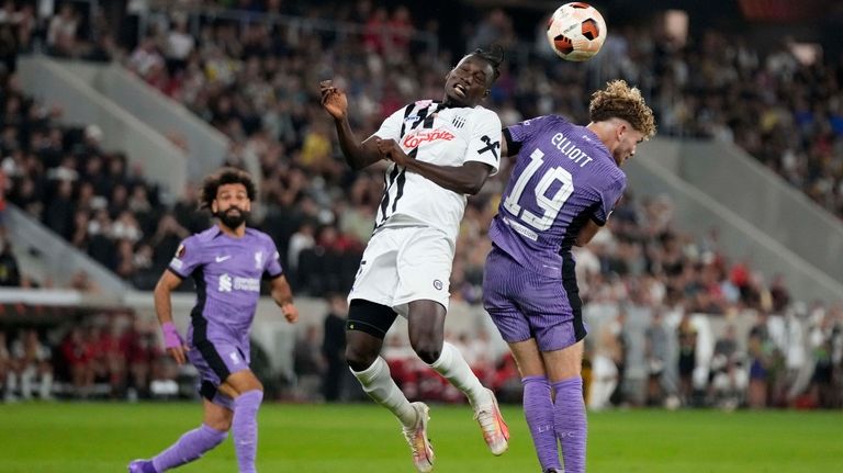 Liverpool's Harvey Elliott, left, and LASK's Ebrima Darboe challenge for...