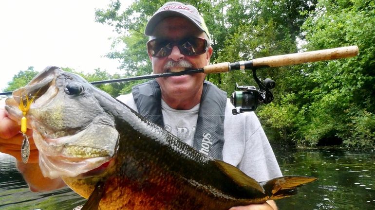 Eric Fieldstadt, of Medford, shows off a largemouth bass he...