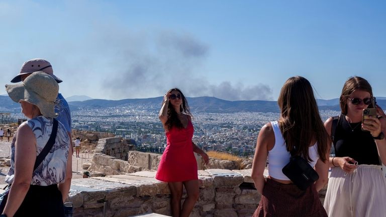 A woman poses for a photo with smoke from a...