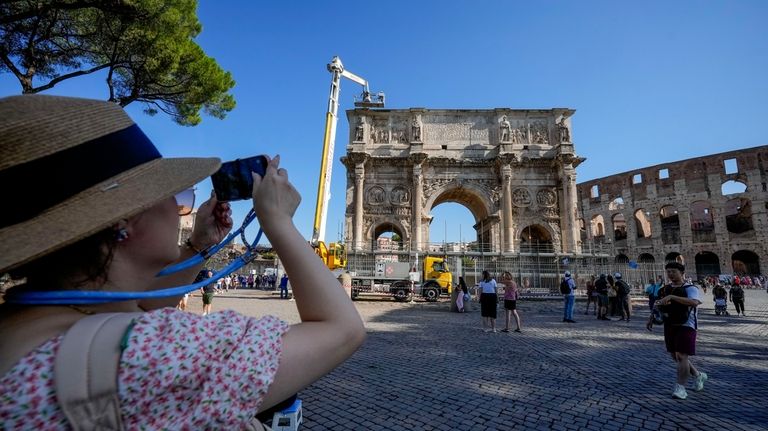 A tourist takes photos of the 315 A.D Arch of...