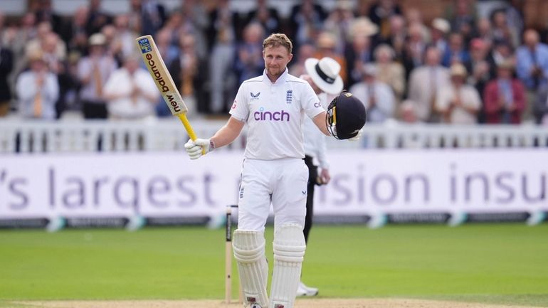 England's Joe Root celebrates a century during day one of...