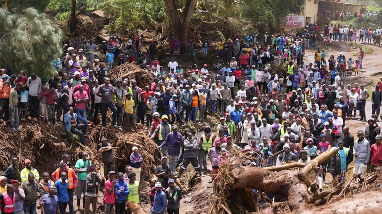 People gather on a bridge after floodwater washed away houses...
