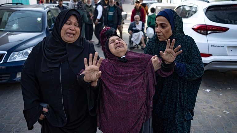 Palestinians mourn their relatives killed in the Israeli bombardment of...