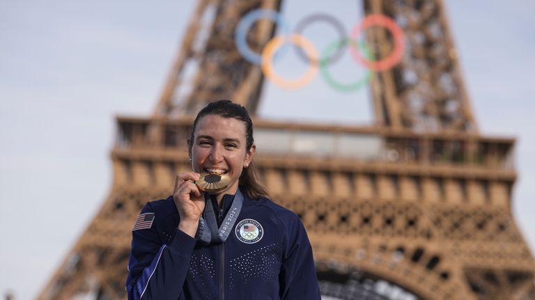 Kristen Faulkner, of the United States, bites the gold medal...