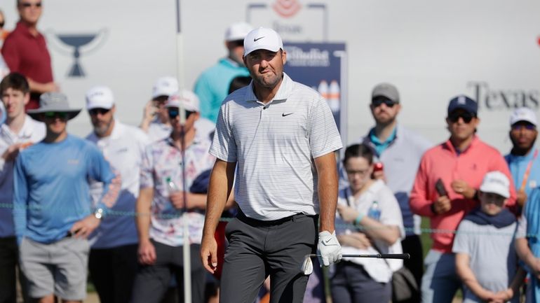 Scottie Scheffler looks at the pin before hitting out of...