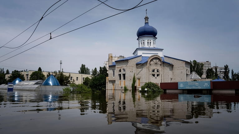 A church surrounded by water in a flooded neighborhood in...