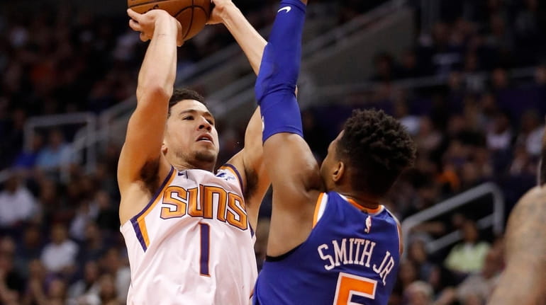 Suns guard Devin Booker shoots over Knicks guard Dennis Smith...