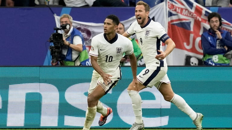 England's Jude Bellingham celebrates with Harry Kane, right, after scoring...
