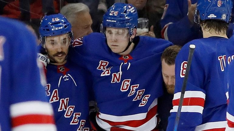 Kaapo Kakko of the Rangers is helped off the ice after...