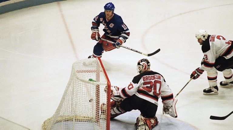 Rangers' Mark Messier puts the puck in the net past...