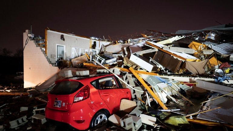 A car is buried under rubble on Main Street after...