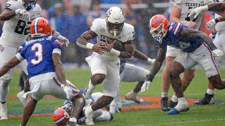 Texas A&M running back EJ Smith, center, runs between Florida...