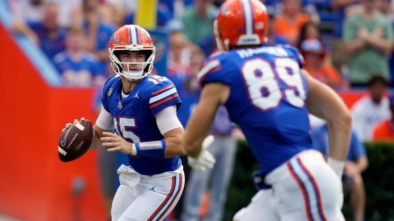 Florida quarterback Graham Mertz, left, looks for receiver tight end...