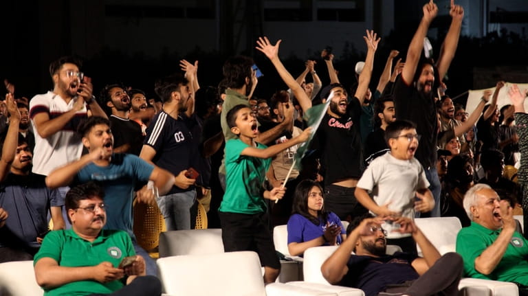 Pakistani cricket fans react while they watch the ICC Men's...