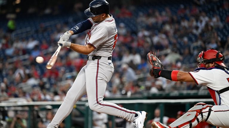 Atlanta Braves' Matt Olson, left, hits a RBI double in...