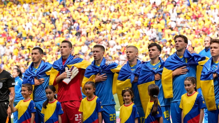 Ukrainian players sing their national anthem prior to a Group...