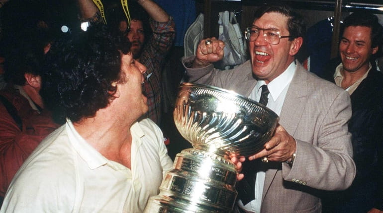 Islanders head coach Al Arbour, right, celebrates the team's fourth-straight...